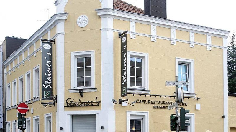 Das Eckhaus an der Waldhausener Straße mit den „Stainer's“-Bannern und dem Schild „Café, Restaurant Stainer's · Biergarten“