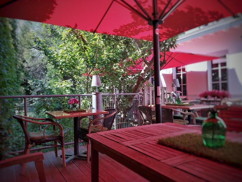 Terrasse mit roten Sonnenschirmen und Holzdielen